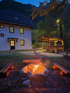 a fire pit in a yard in front of a house at Apartment Hosner in Lepena