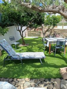 a garden with a table and chairs in the grass at Outra Vida in Mértola