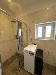 a bathroom with a shower and a small refrigerator at Elia in Marathon +54 photos
