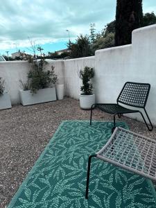 a patio with a bench and a fence with plants at Logis des pêcheurs in Meschers-sur-Gironde