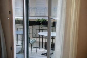 a balcony with a table and a window at ASO Hotel - Historic Raisin Warehouse 1928 in Kalamata
