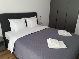 a large bed with two white towels on it at Sterling House in Timişoara +2 photos