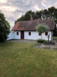 a small white house with a statue in front of it at Drängagården in Klagstorp