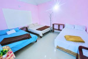 two beds in a room with pink walls at munnar Green portico Cottages in Anachal +67 photos