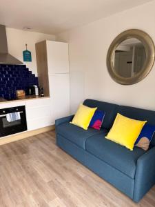 a blue couch with yellow pillows in a living room at Logis des pêcheurs in Meschers-sur-Gironde