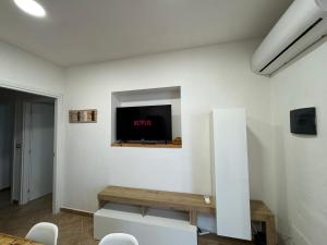 a living room with a tv on a white wall at Casa via veneto in Carbonia +18 photos