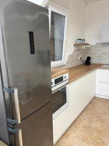 a kitchen with a stainless steel refrigerator and a window at Casa via veneto in Carbonia