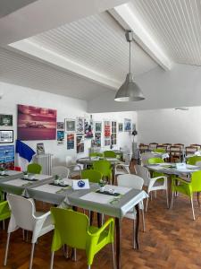 a restaurant with green chairs and tables in a room at Hôtel Castel Saint Anne in Le Castellet