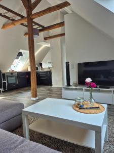 a living room with a white coffee table and a kitchen at Ferienwohnung bei Nebel in Mandelsloh in Neustadt am Rübenberge