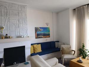 a living room with a blue couch and a fireplace at Surf House in Artemida