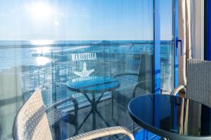a balcony with a table and chairs and a view of the ocean at Blu Mare Residense in Odesa
