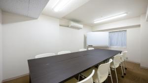 a conference room with a black table and white chairs at Quintessa Hotel Akita in Akita