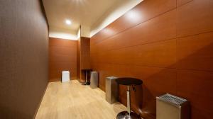a hallway with wooden walls and a stool in a room at Quintessa Hotel Akita in Akita