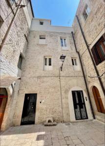 a large brick building with two black doors at Casa-Torre Normanna in Bitonto