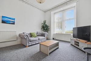 a living room with a couch and a flat screen tv at 173 Newark Street, Greenock in Greenock