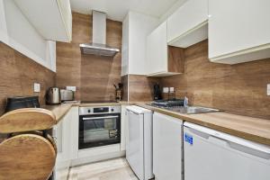 a kitchen with white cabinets and a sink at 173 Newark Street, Greenock in Greenock