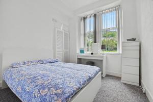 a bedroom with a bed and a desk and window at 173 Newark Street, Greenock in Greenock