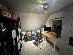 a room with a desk with a computer and a couch at An der Elbaue in Pirna