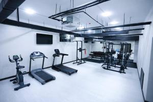 a gym with several treadmills and machines in a room at Рамада Нукус in Nukus