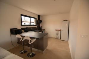 a kitchen with a counter and a refrigerator at Villa au calme avec piscine privée - Lac de Jouarres in Olonzac