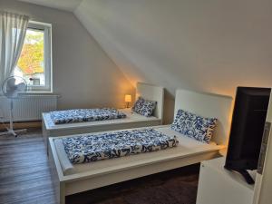 two beds in a room with a tv at Ferienwohnung bei Nebel in Mandelsloh in Neustadt am Rübenberge