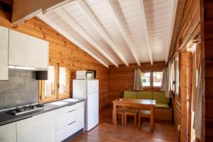 a kitchen with a table and a refrigerator at Camping Cambrils Caban in Cambrils