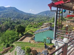 a view of a mountain with a blue house at Nilkanth gest hause in Mukteshwar
