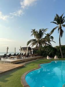 a resort with a swimming pool and palm trees and the ocean at 4U Resort Samui in Lamai