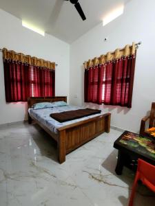 a bedroom with a bed and red curtains at Deepa HomeStay in Dharmastala