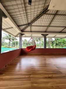 a room with a red hammock hanging from the ceiling at Deepa HomeStay in Dharmastala