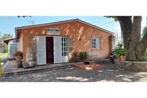 a small orange building with a white door at Capital O Posada Del Pescador Jocotepec in Chapala