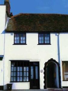 a white house with a black door and windows at Larkin House in Rye