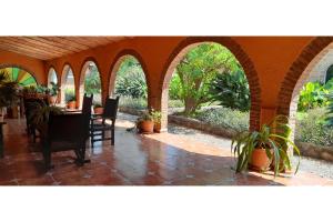 an outdoor patio with a table and chairs and plants at Capital O Posada Del Pescador Jocotepec in Chapala +62 photos