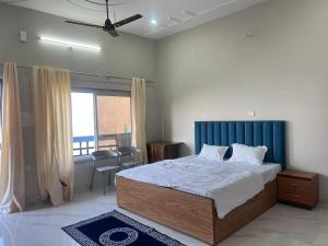 a bedroom with a large bed with a blue headboard at The City View Homestay in Srīnagar