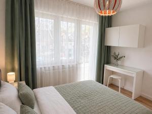 a bedroom with a bed and a desk and a window at Apartamenty Przy Forcie in Kłodzko
