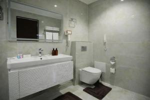 a bathroom with a sink and a toilet and a mirror at Рамада Нукус in Nukus +14 photos