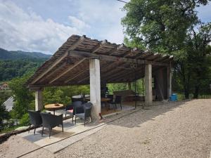 a wooden pergola with chairs and a table at Apartmaji pr'Muranček in Radovljica