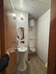 a bathroom with a sink and a toilet at Hotel Atithyam in Solan
