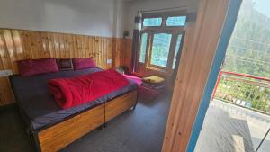 ein Schlafzimmer mit einem Bett mit roter Bettwäsche und einem Fenster in der Unterkunft FORMOSA Cafe Hostel KASOL GOA in Kasol + 201 Fotos