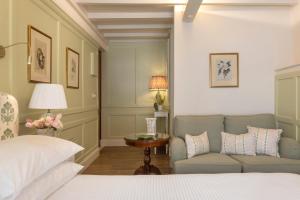 a bedroom with a bed and a couch and a table at Despotiko Hotel in Mikonos