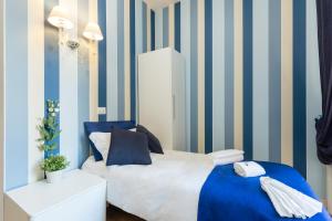 Schlafzimmer mit einem Bett mit blauen und gestreiften Wänden in der Unterkunft Rione Monti Suites in Rom