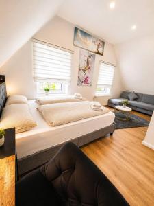 ein großes Schlafzimmer mit zwei Betten und einer Couch in der Unterkunft SmartStay Wuppertal Self Check-in Parking Budget Hotel in Wuppertal