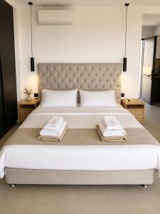 ein Schlafzimmer mit einem großen Bett, auf dem zwei Handtücher liegen in der Unterkunft Mat Suites in Lachania