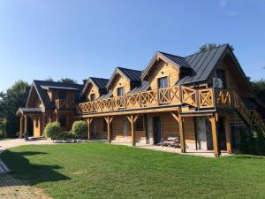 a large wooden house with a gambrel roof at Kocyłówka in Stara Kamionka