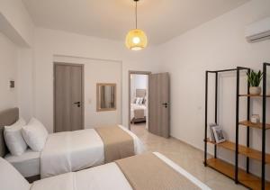 a white bedroom with two beds and a couch at Artemis Studios - Pool and garden in Koskinou +81 photos