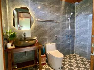 a bathroom with a sink and a toilet and a mirror at Rocky Mountain Ecology in Xuân Sơn +21 photos