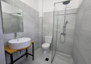 a bathroom with a toilet and a sink and a shower at Artemis Studios - Pool and garden in Koskinou