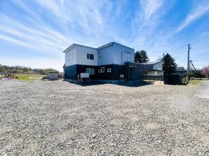 a large blue house sitting on top of a gravel lot at Villa和心 in Asahikawa