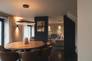 a dining room with a wooden table and chairs at Stone Barn Menil Sauna & Nordic Bath in Ardennes in Hotton