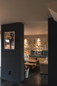 a living room with a couch and a table at Stone Barn Menil Sauna & Nordic Bath in Ardennes in Hotton